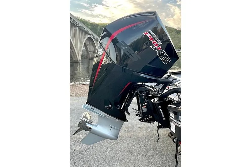 Slide: The Image of 2025 Tracker Savage 215 with Mercury Pro XS outboard motor by a bridge. - 123
