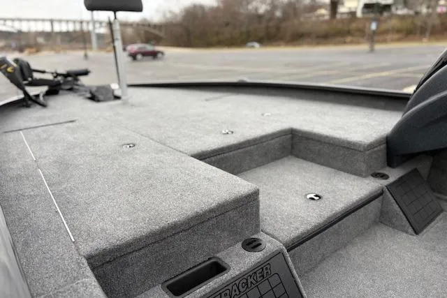 Slide: The Image of 2025 Tracker Savage 215 boat interior with gray carpeted deck and storage compartments. - 125