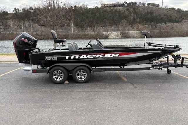 Slide: The Image of 2025 Tracker Savage 215 boat on trailer by a riverbank. - 132