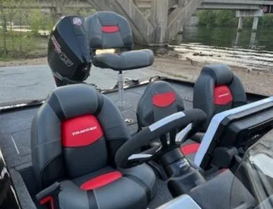 Slide: The Image of 2025 Tracker Savage 215 boat on trailer by a scenic riverside parking lot. - 6