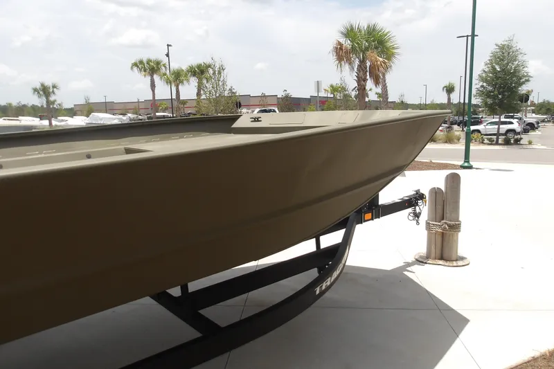 Slide: The Image of 2025 Tracker Grizzly 2072 Utility boat on trailer, outdoor display with palm trees. - 8