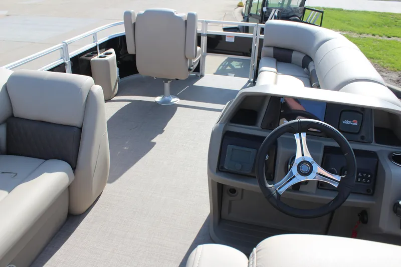 Slide: The Image of 2025 Sun Tracker SportFish 20 DLX pontoon boat interior with steering wheel and seating. - 17