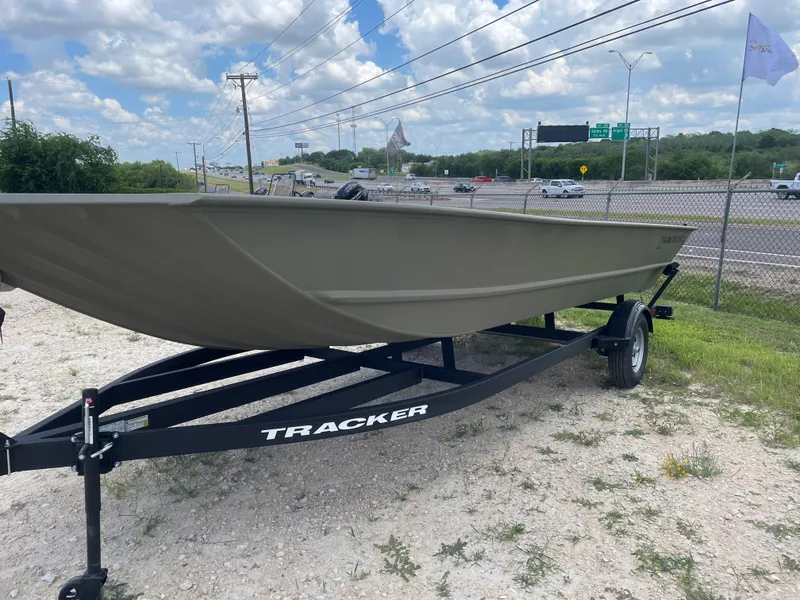 Slide: The Image of 2025 Tracker GRIZZLY 2072 Utility boat on trailer, parked near highway under blue sky. - 2