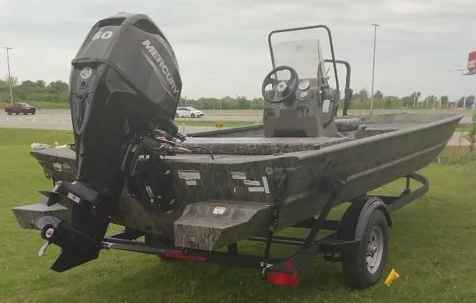 Slide: The Image of 2025 Tracker Grizzly 1860 CC boat with Mercury engine on trailer, parked on grass. - 3