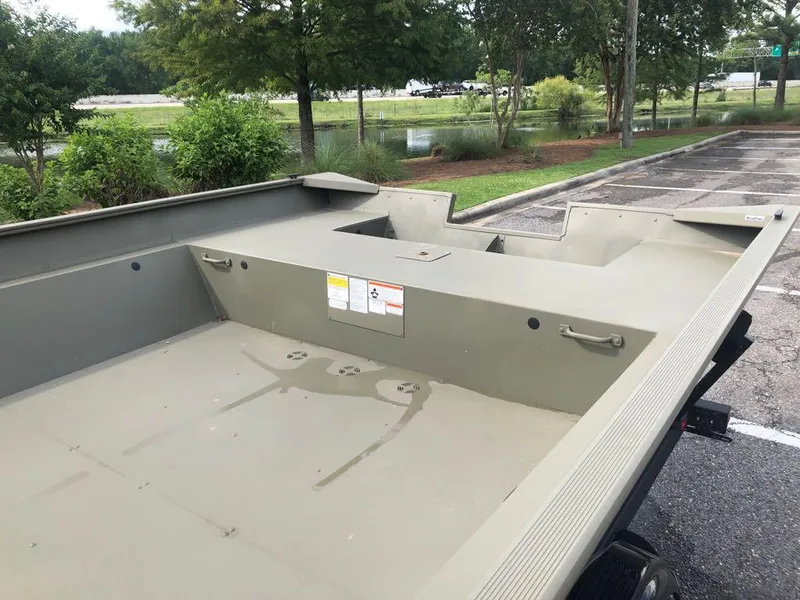 Slide: The Image of 2025 Tracker GRIZZLY 2072 Utility boat in a parking lot, surrounded by greenery. - 9