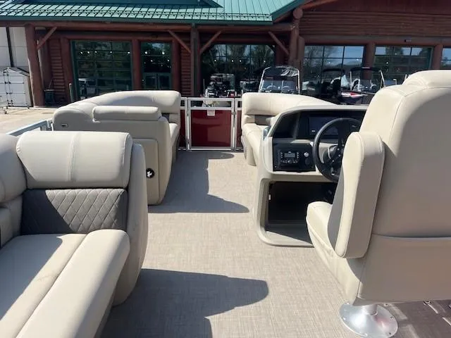 Slide: The Image of 2025 Sun Tracker Party Barge 20 DLX interior with beige seating and steering console. - 3