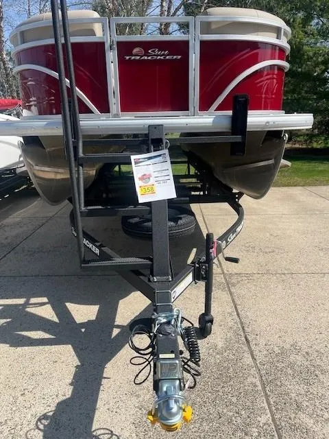 Slide: The Image of 2025 Sun Tracker Party Barge 20 DLX pontoon boat, red exterior, parked on a trailer. - 5