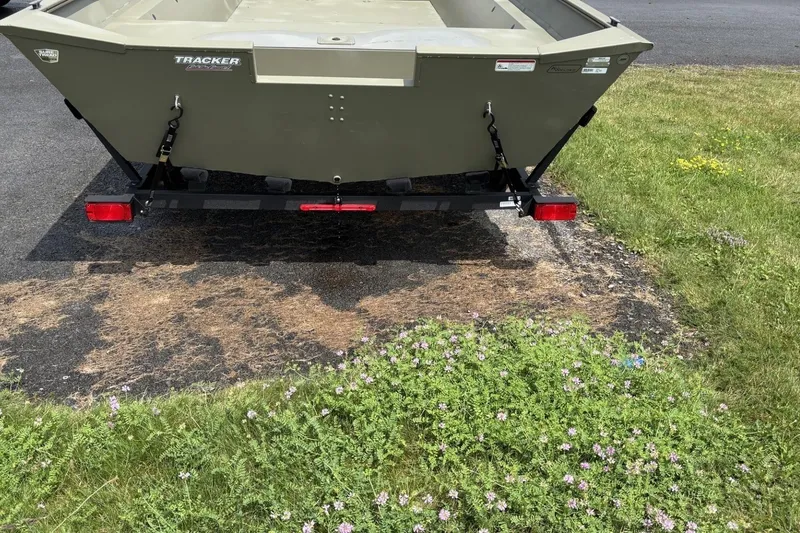 Slide: The Image of 2025 Tracker Grizzly 2072 Utility boat on trailer, parked on grass and pavement. - 2