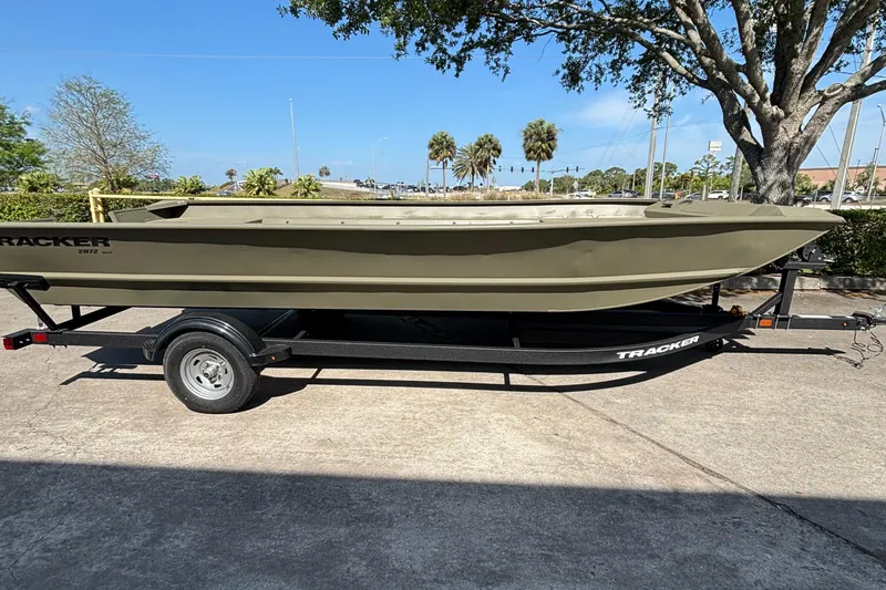 The Image of 2025 Tracker GRIZZLY 2072 Utility boat on trailer, parked outdoors. - 0