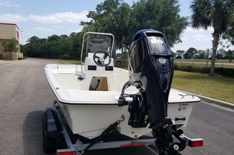 Slide: The Image of 2025 Mako Pro Skiff 15 CC boat on trailer with 80 HP outboard motor. - 2