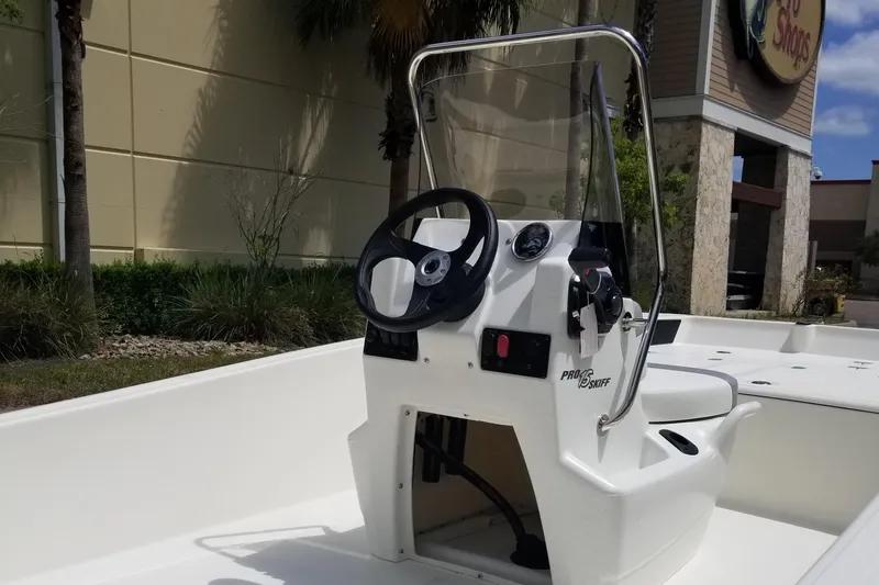 Slide: The Image of 2025 Mako Pro Skiff 15 CC boat with center console and steering wheel. - 3