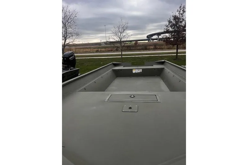 Slide: The Image of 2025 Tracker Grizzly 2072 Utility boat on a cloudy day, parked near trees. - 16