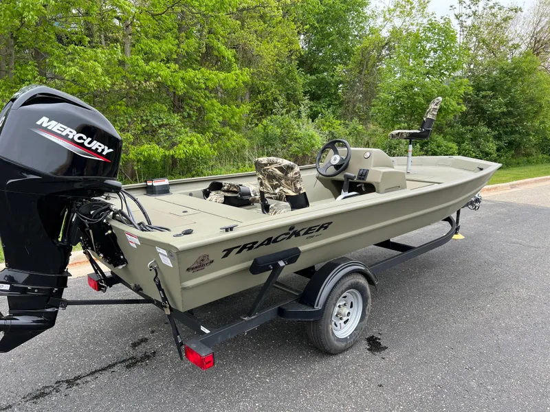 Slide: The Image of 2025 Tracker Grizzly 1754 SC boat with Mercury engine on trailer, parked outdoors. - 3