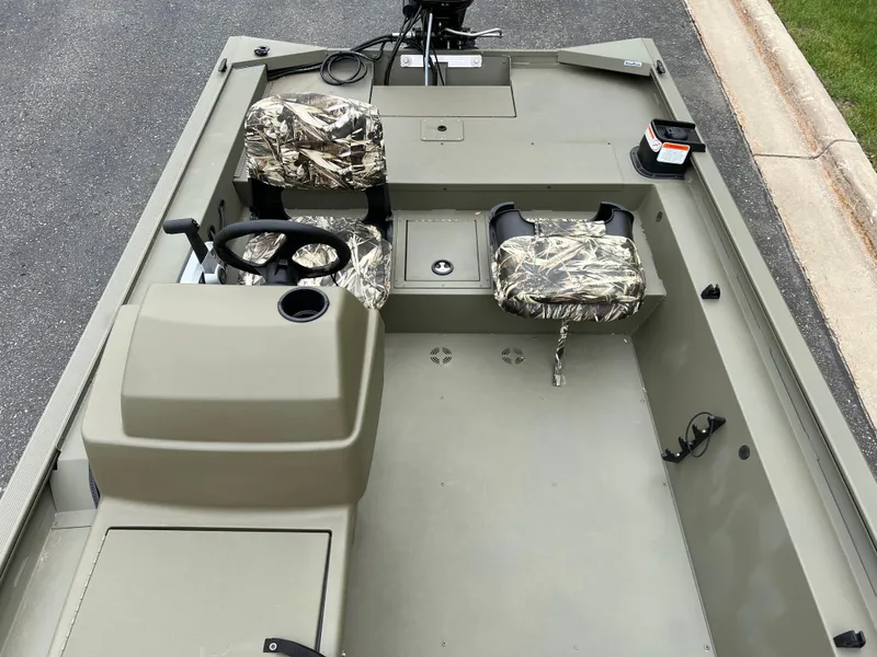 Slide: The Image of 2025 Tracker Grizzly 1754 SC boat interior with camouflage seats and steering console. - 5