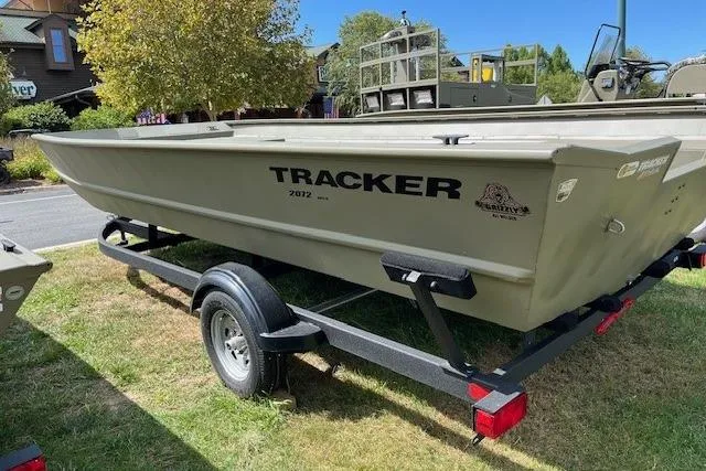 Slide: The Image of 2025 Tracker Grizzly 2072 Utility boat on trailer, parked outdoors. - 2