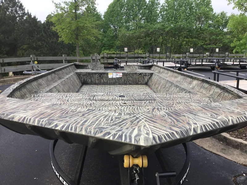 Slide: The Image of 2025 Tracker GRIZZLY 2072 Utility boat with camouflage design, parked outdoors. - 1