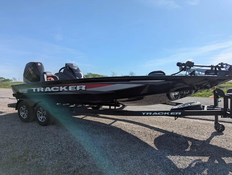 Slide: The Image of 2025 Tracker Savage 215 boat on trailer under clear blue sky. - 10