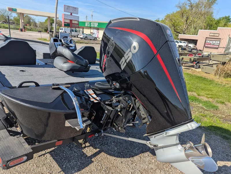 Slide: The Image of 2025 Tracker Savage 215 boat with powerful outboard motor, parked outdoors. - 5