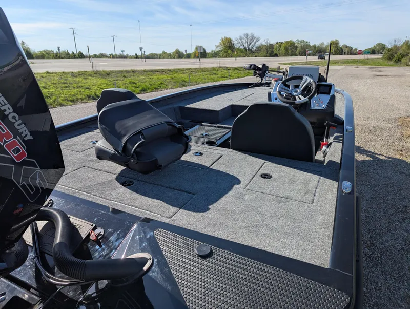Slide: The Image of 2025 Tracker Savage 215 boat interior with steering wheel and seating, parked outdoors. - 6