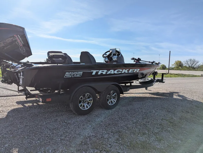 Slide: The Image of 2025 Tracker Savage 215 boat on trailer under clear blue sky. - 8