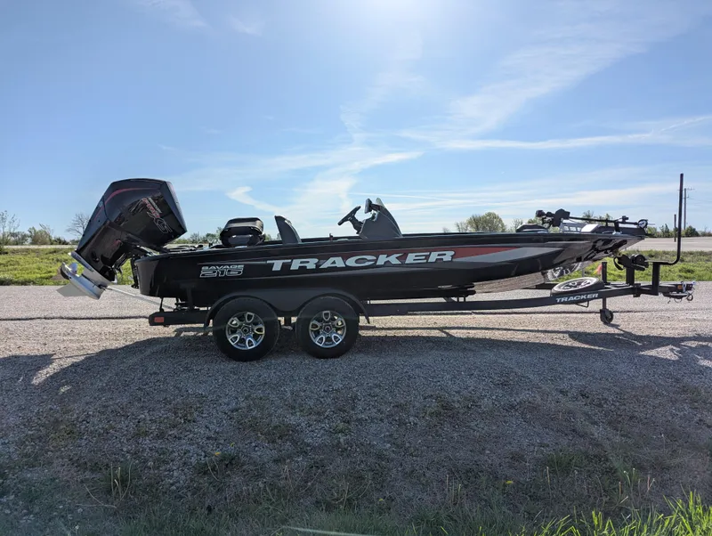 Slide: The Image of 2025 Tracker Savage 215 boat on trailer, parked outdoors under clear sky. - 9