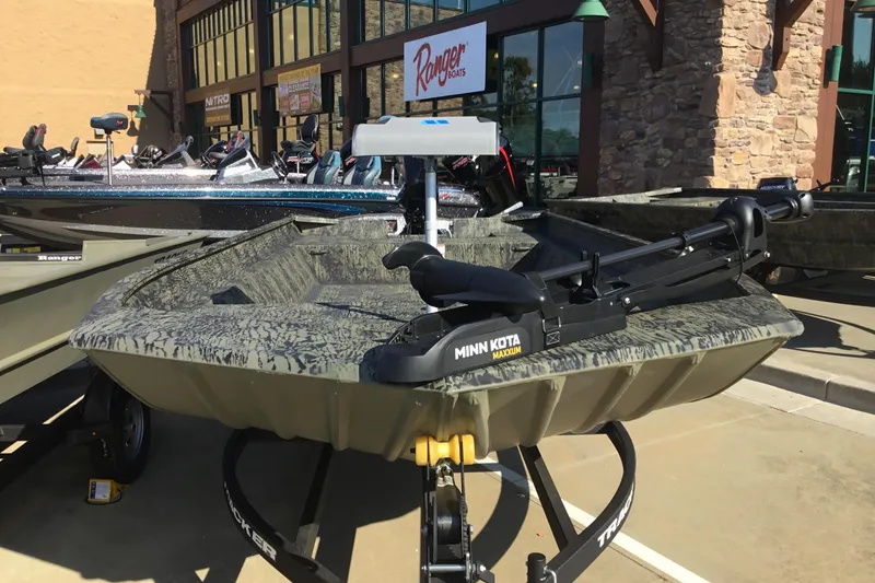 Slide: The Image of 2025 Tracker Grizzly 2072 Utility boat with Minn Kota Maxxum motor displayed outdoors. - 2