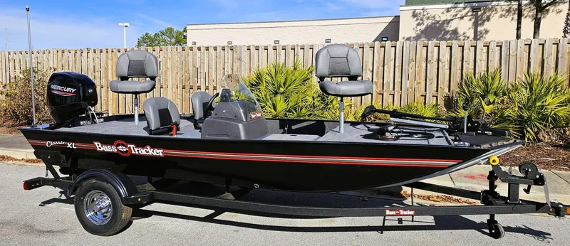 Slide: The Image of 2025 Tracker Bass Tracker Classic XL fishing boat on trailer, parked outdoors. - 2