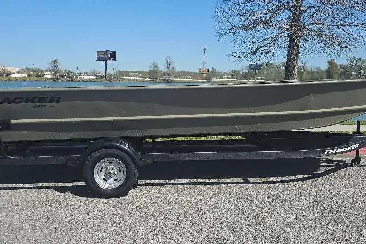 Slide: The Image of 2025 Tracker Grizzly 2072 Utility boat on trailer by a lake. - 21