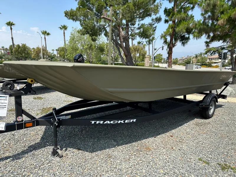 The Image of 2025 Tracker GRIZZLY 2072 Utility boat on trailer, parked outdoors, surrounded by trees. - 0