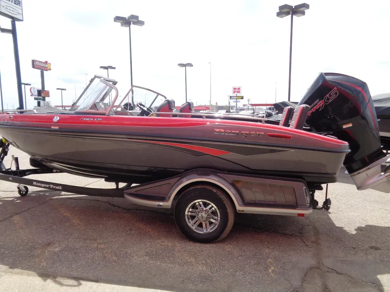 Slide: The Image of 2025 Ranger 1880MS boat with red and gray design on a trailer in a parking lot. - 5