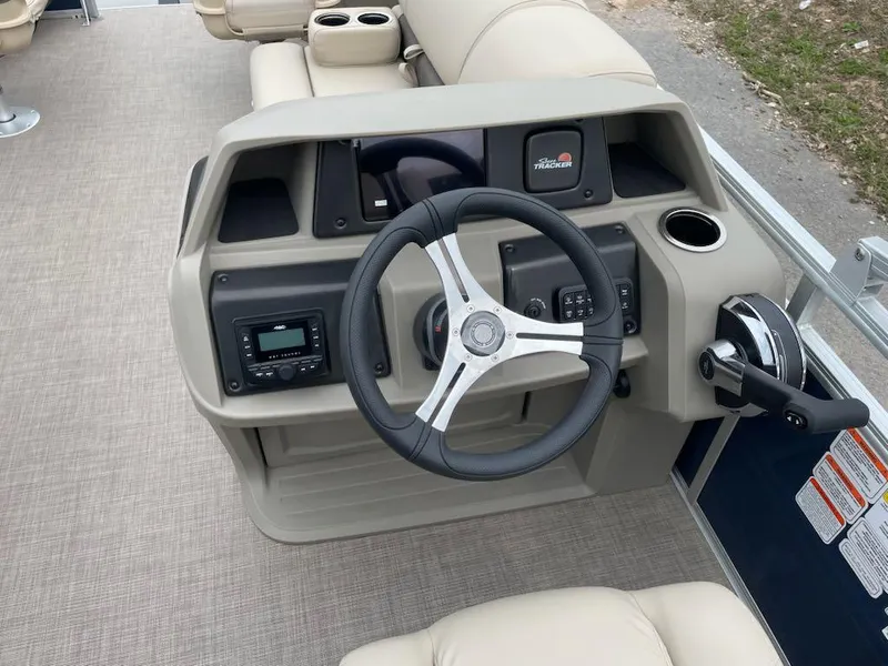 Slide: The Image of 2025 Sun Tracker Fishin' Barge 20 DLX helm with steering wheel and controls. - 2