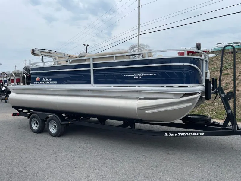 Slide: The Image of 2025 Sun Tracker Fishin' Barge 20 DLX pontoon boat on trailer, side view. - 4