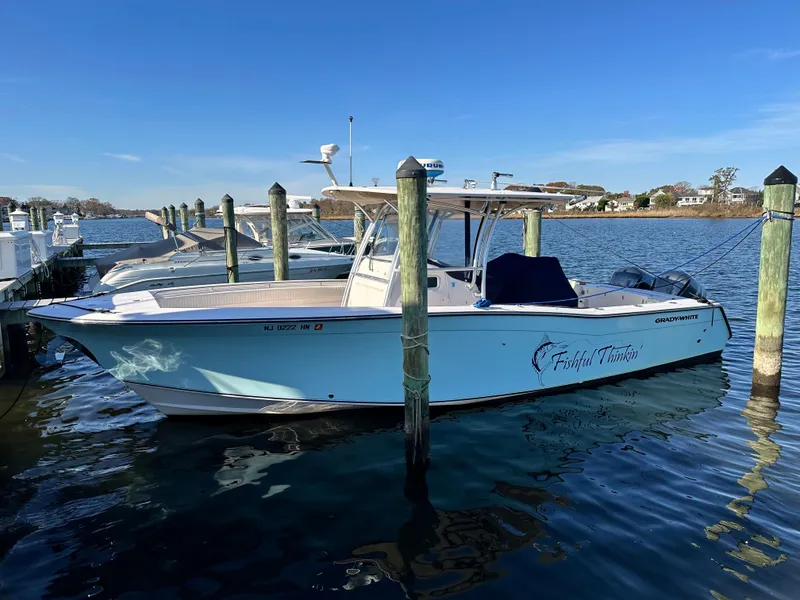 Slide: The Image of 2008 Grady-White Bimini 306 boat docked in a marina on a sunny day. - 0
