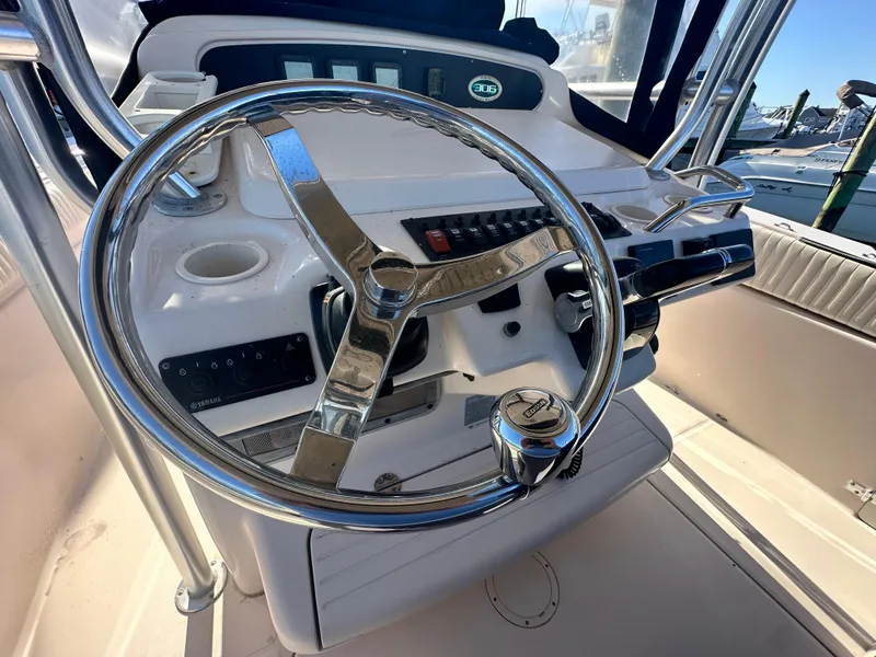 Slide: The Image of Steering wheel and controls of a 2008 Grady-White Bimini 306 boat. - 17