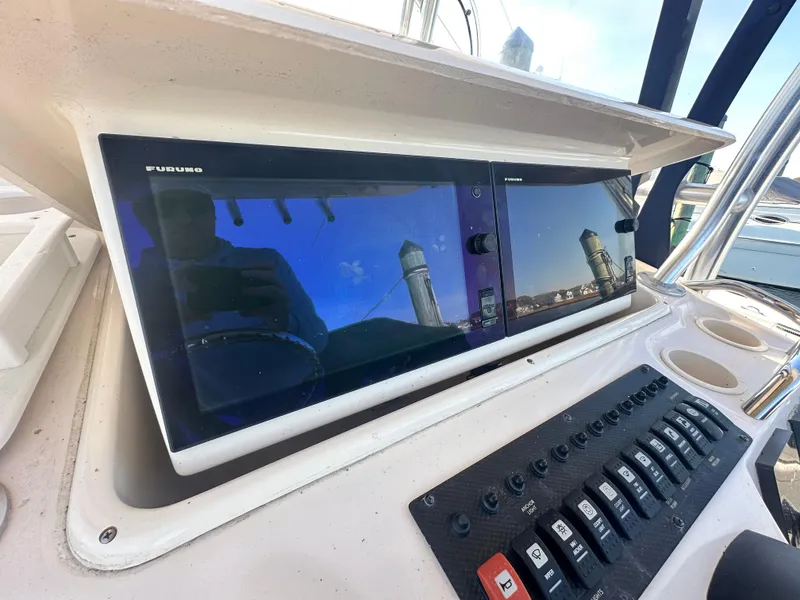 Slide: The Image of 2008 Grady-White Bimini 306 dashboard with dual Furuno displays and control panel. - 19