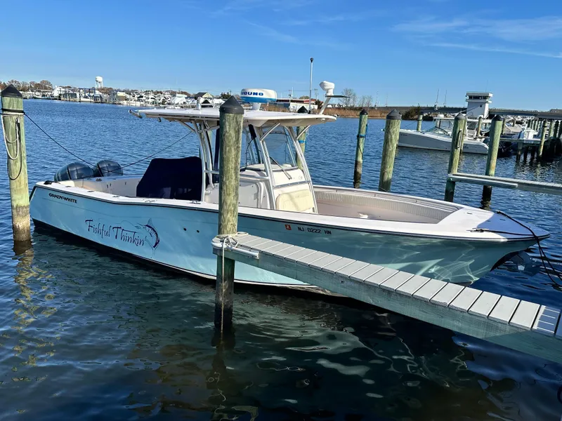 Slide: The Image of 2008 Grady-White Bimini 306 boat docked in a marina under clear blue skies. - 3