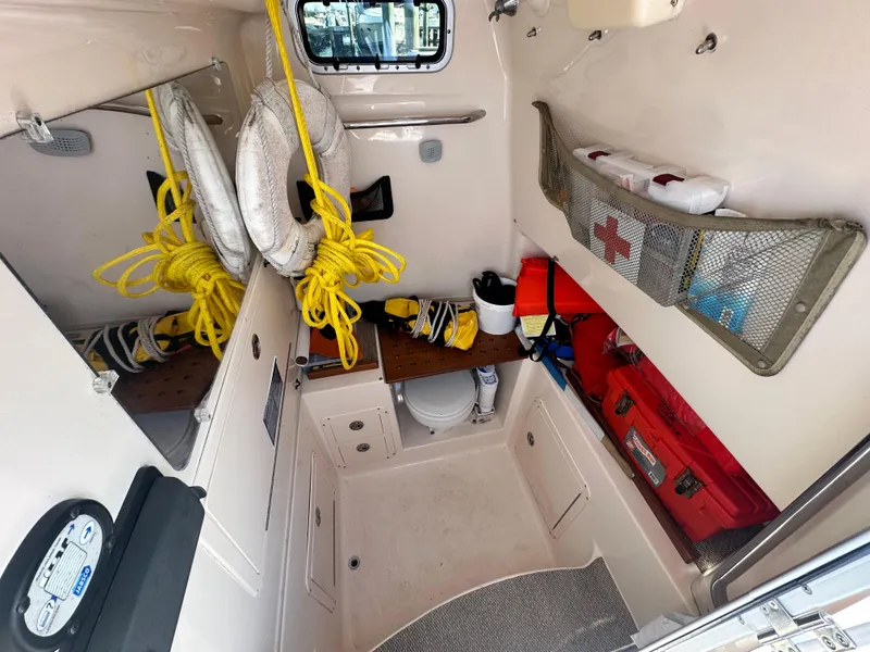 Slide: The Image of 2008 Grady-White Bimini 306 cabin interior with safety equipment and storage. - 34