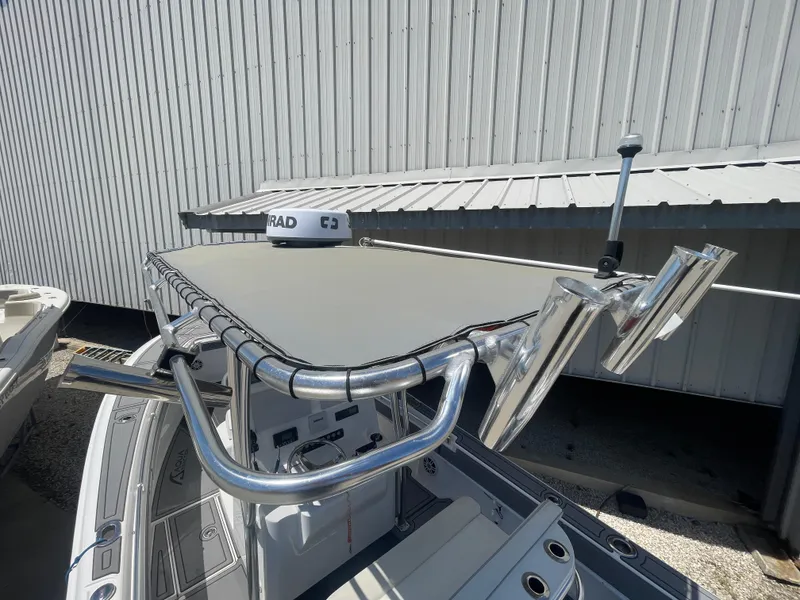 Slide: The Image of 2022 Contender 25 Tournament boat with radar and rod holders, docked near a metal building. - 17