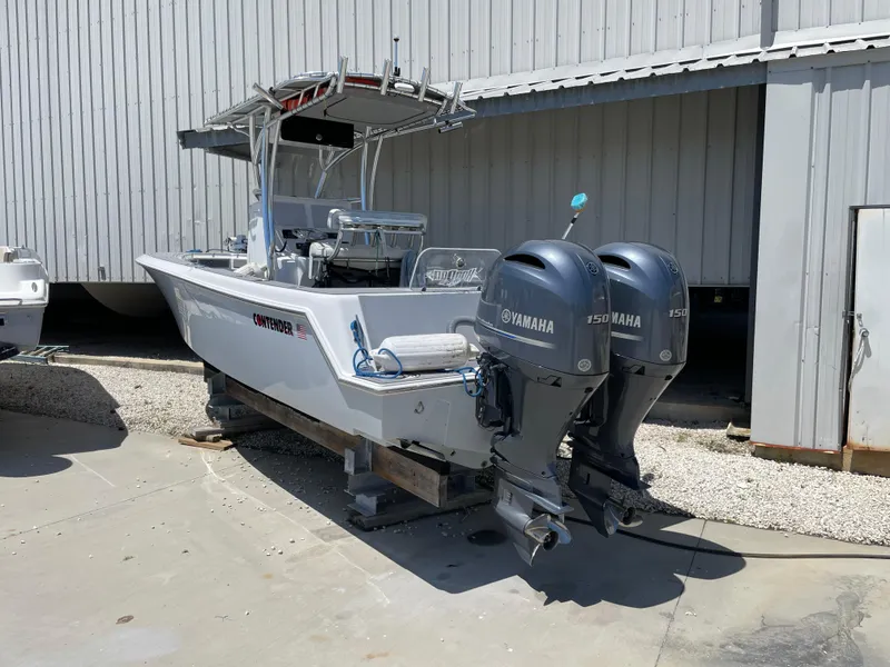 Slide: The Image of 2022 Contender 25 Tournament boat with dual Yamaha engines, parked outdoors. - 2