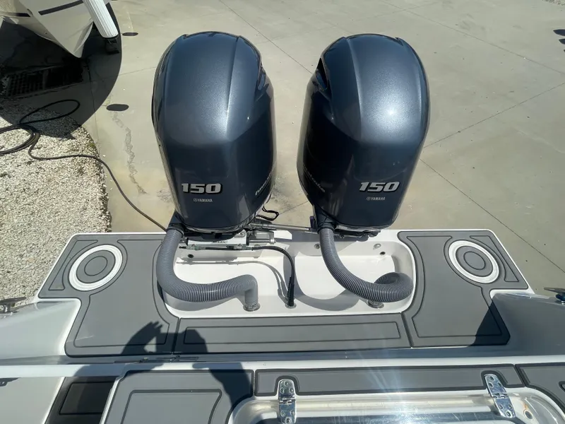 Slide: The Image of Twin Yamaha 150 engines on a 2022 Contender 25 Tournament boat, docked on concrete. - 20