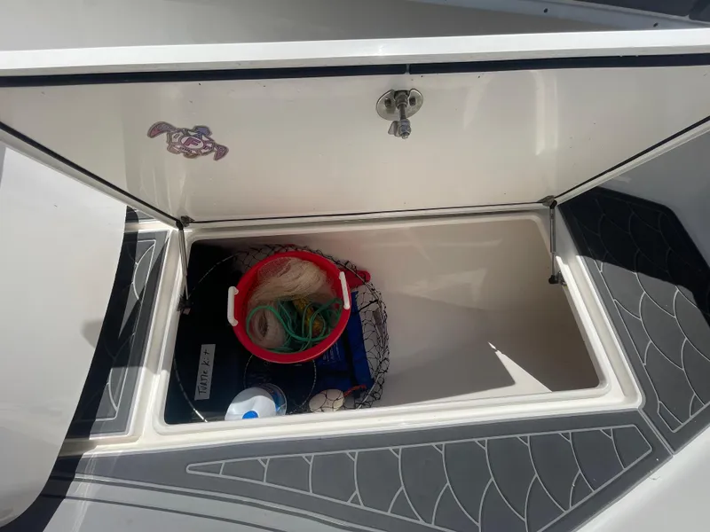 Slide: The Image of Open storage compartment on 2022 Contender 25 Tournament boat with fishing gear inside. - 22