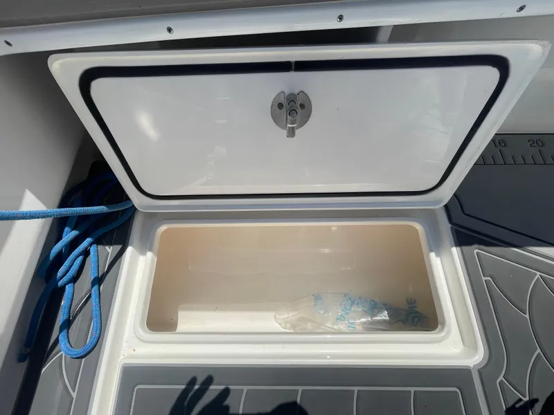 Slide: The Image of Open storage compartment on 2022 Contender 25 Tournament boat with blue rope. - 26
