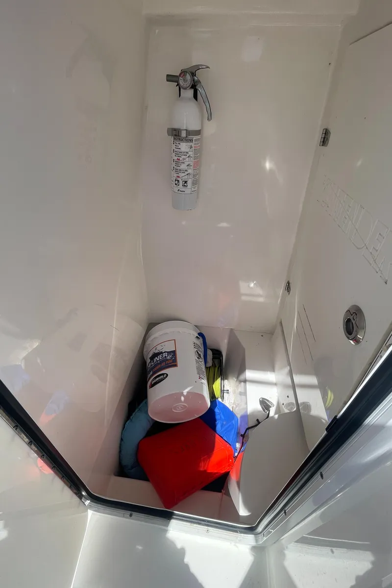 Slide: The Image of 2022 Contender 25 Tournament storage compartment with fire extinguisher and cleaning supplies. - 28