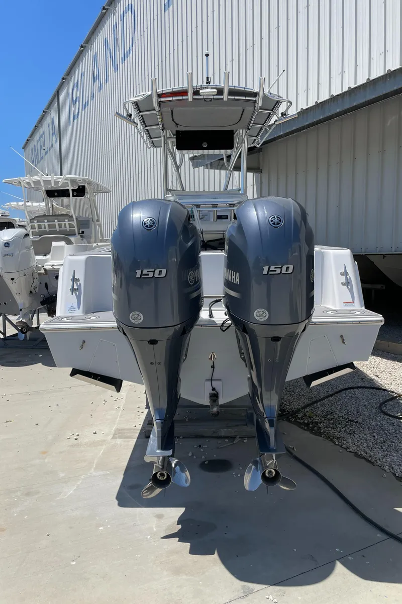 Slide: The Image of 2022 Contender 25 Tournament boat with dual Yamaha 150 engines, docked outdoors. - 3