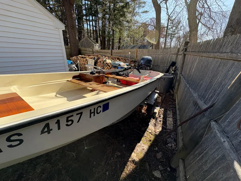 Slide: The Image of 1987 Boston Whaler 13 boat parked outdoors near a wooden fence. - 3
