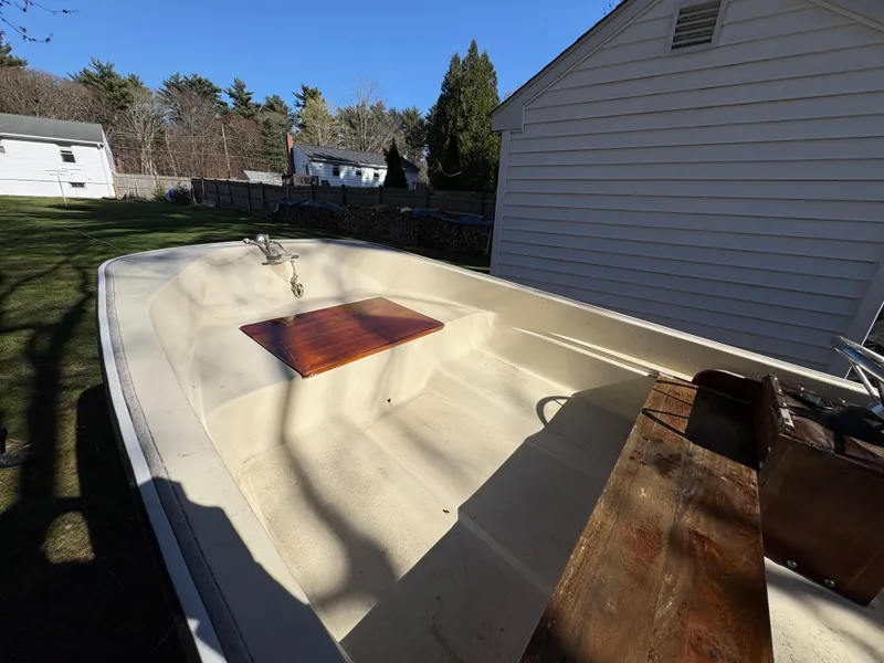 Slide: The Image of 1987 Boston Whaler 13 boat in a backyard, showcasing its interior and wooden details. - 7