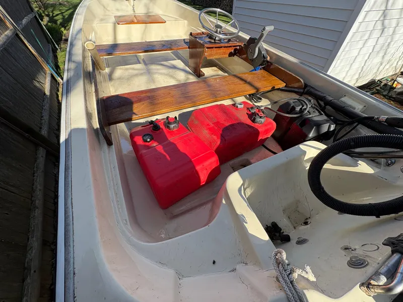 Slide: The Image of 1987 Boston Whaler 13 boat interior with red fuel tanks and wooden seating. - 8