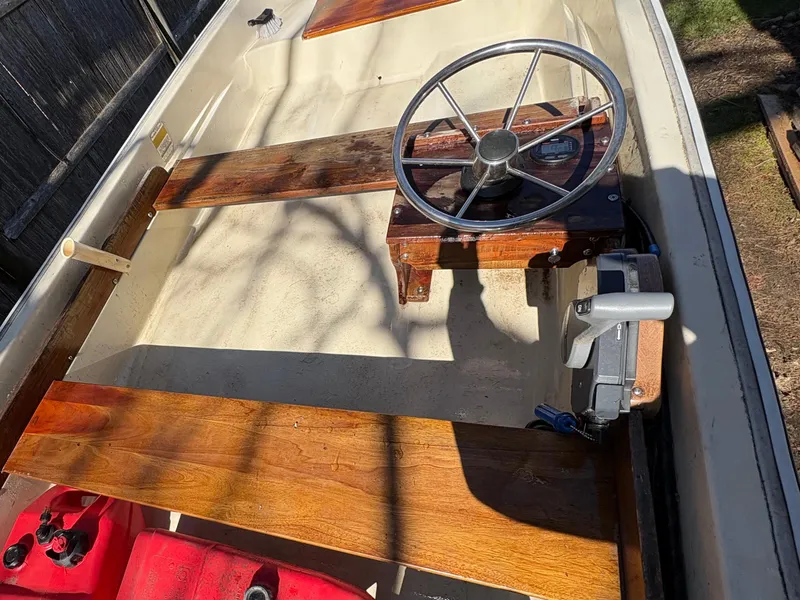 Slide: The Image of 1987 Boston Whaler 13 boat interior with wooden seats and steering wheel. - 9