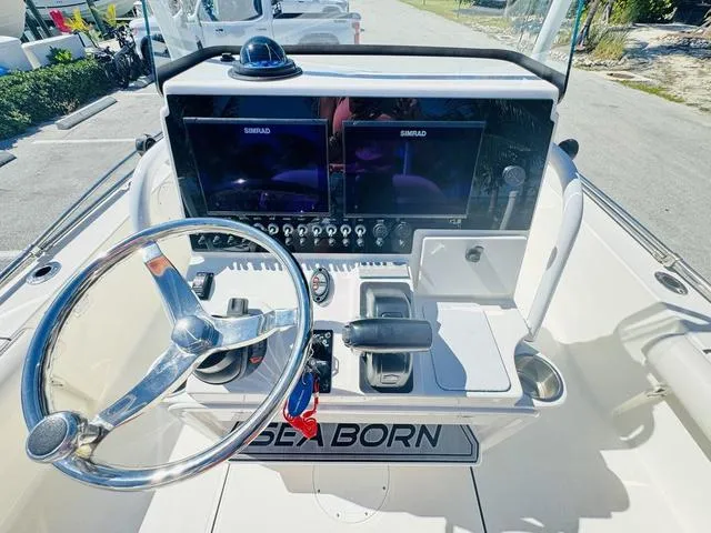 Slide: The Image of 2021 Sea Born FX24 boat dashboard with dual Simrad displays and steering wheel. - 12