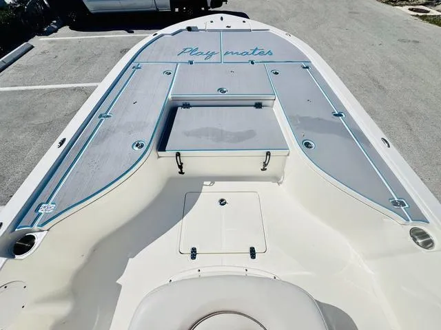 Slide: The Image of 2021 Sea Born FX24 boat deck with "Play mates" text, parked on pavement. - 14